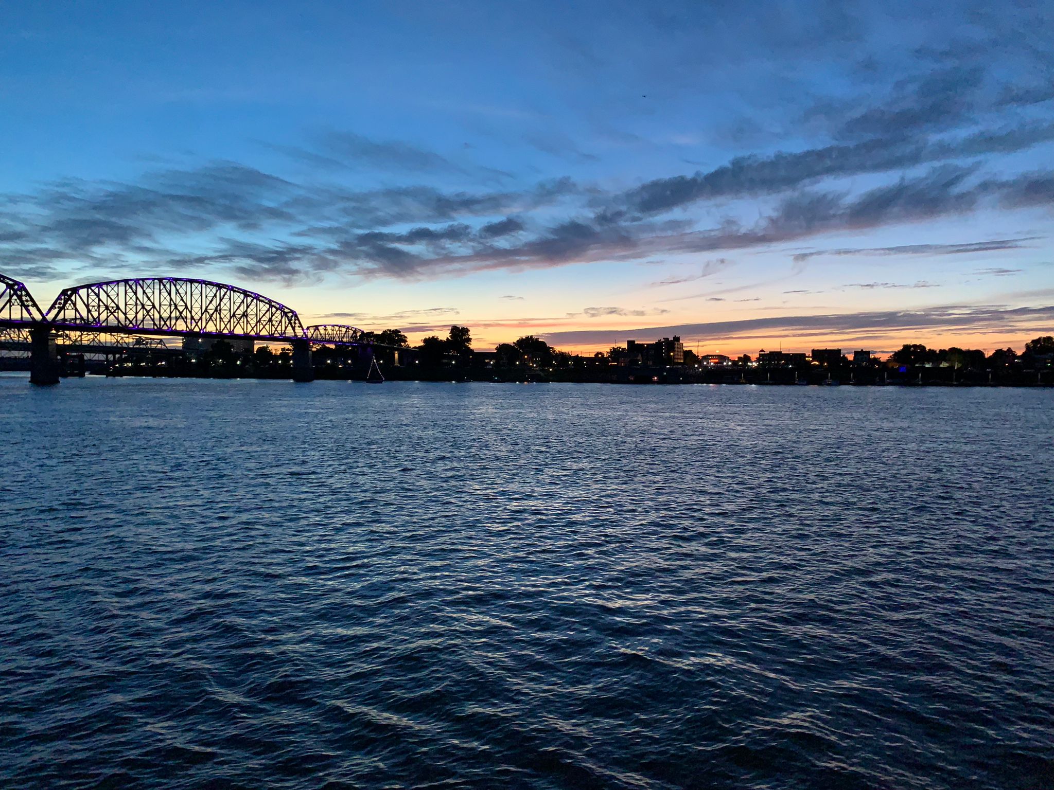 L'eau, le ciel, et des arbes au millieu, un pont au loin