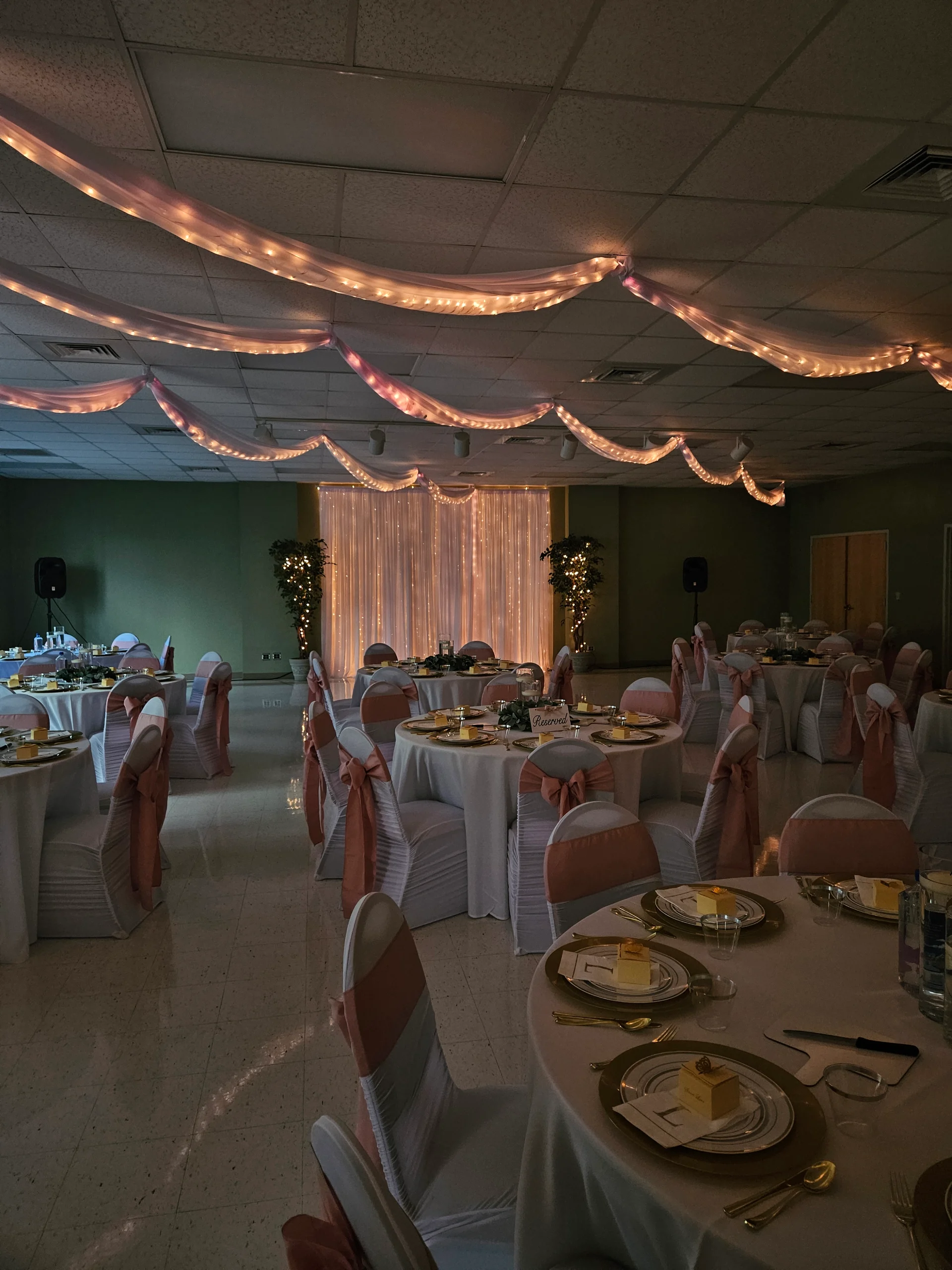 Des tables avec des chaises blanches ornées de noeuds roses et de belles lumières